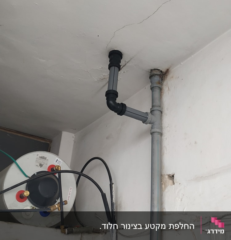 צינור פלסטיק אפור מחובר לתקרה עם חיבורים שחורים